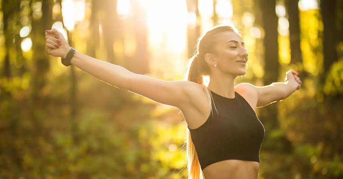 Mujer enérgica al aire libre disfrutando de bienestar gracias al magnesio
