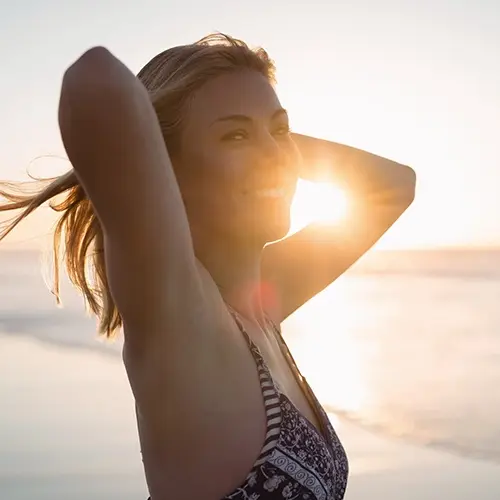 Mujer en la puesta del sol sonriente