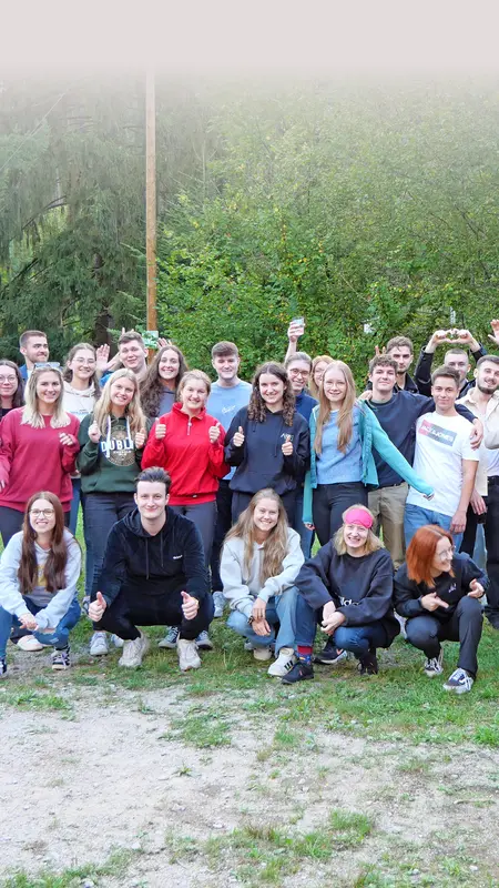 Gruppenbild: Heel-Azubis lachen in die Kamera und winken beim Azubi-Event.