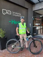Heel Kolumbien Mitarbeiter steht mit Fahrrad vor Heel-Eingang.
