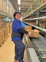 Heel Mitarbeiterin verpackt die Heel Produkte in Kartons. 