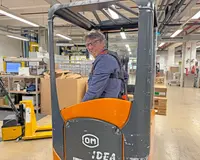 Heel Mitarbeiter fährt mit dem Stapler durch das Lager.
