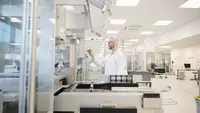 Mitarbeiter aus der Produktion bedient eine Maschine. 