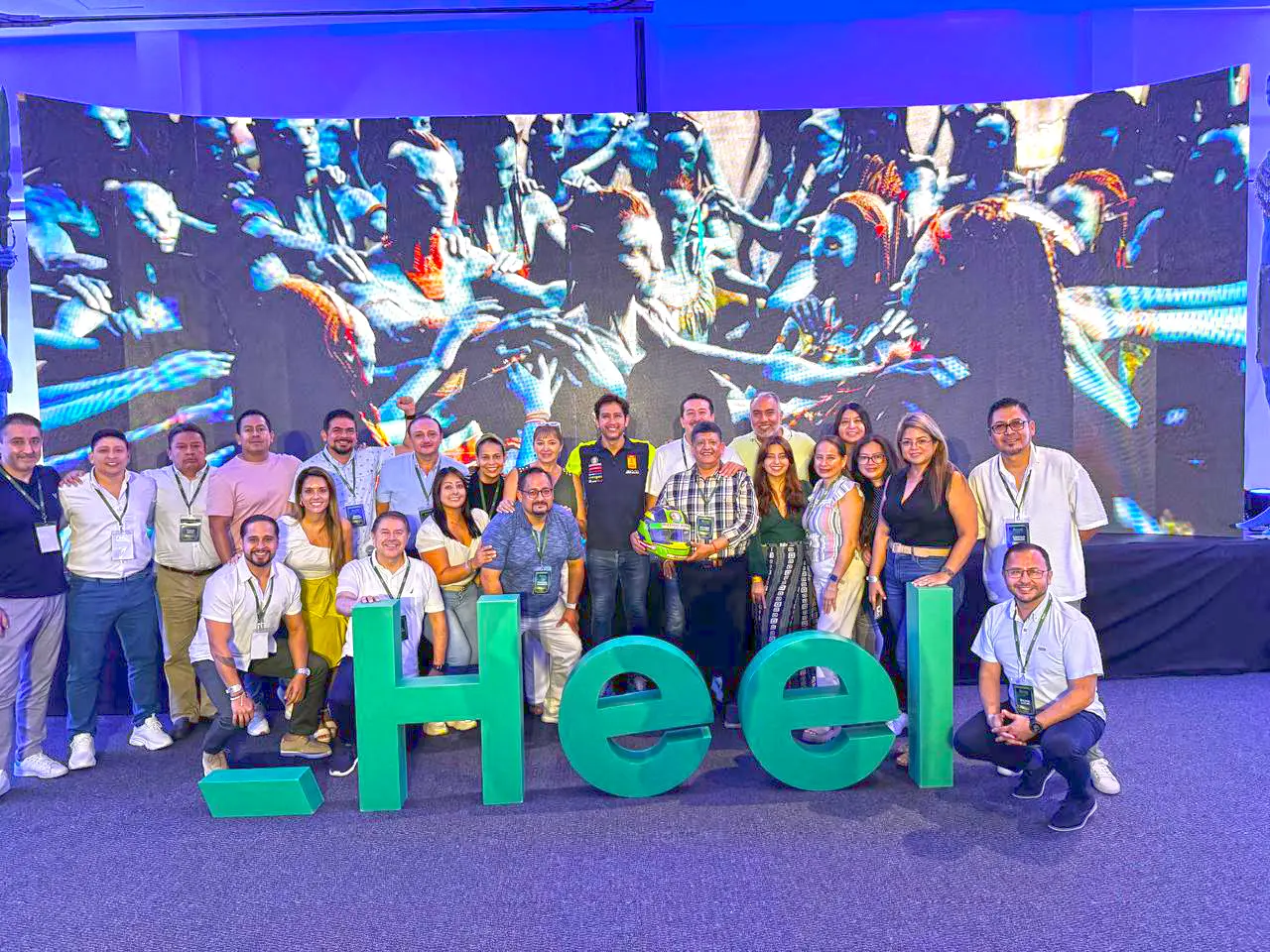 Heel Ecuador Mitarbeiter stehen vor Heel Logo mit dem Film Avatar im Hintergrund.