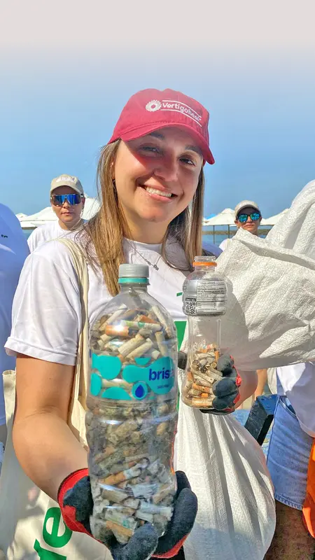 Heel Kolumbien Mitarbeiterin präsentiert Flasche mit gesammelten Zigarettenstummeln.
