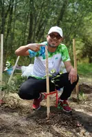 Heel Ecuador Mitarbeiter präsentiert seinen frisch gepflanzten Baum