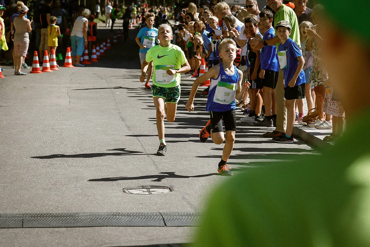 Zieleinlauf zweier Schueler vor applaudierenden Fans beim Heel-Lauf
